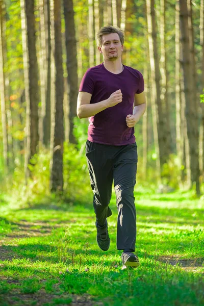 Man jogging in city partk at beautiful summer day. Sport fitness model caucasian ethnicity training outdoor. — Stock Photo, Image