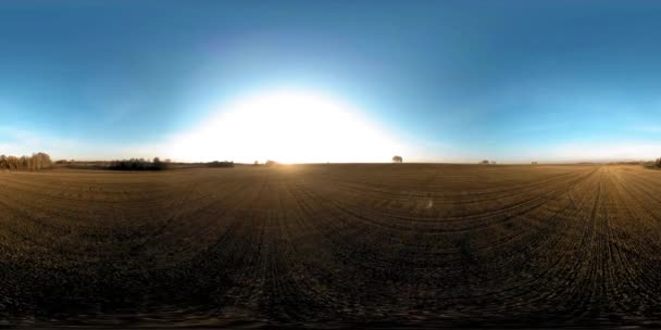 360 légi felvétel. Alacsony repülés a vidéki nyári táj felett végtelen zöld mezővel a napos őszi estén. Napsugarak a láthatáron. Gyors vízszintes mozgás. Stabilizált és foltozott. — Stock videók