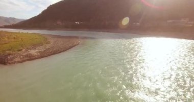 Güneşli yaz sabahında kayalarla birlikte taze, hızlı dağ nehri üzerinde alçak irtifa uçuşu..