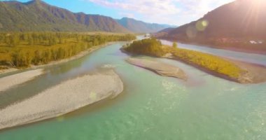 Güneşli yaz sabahında kayalarla birlikte taze, hızlı dağ nehri üzerinde alçak irtifa uçuşu..