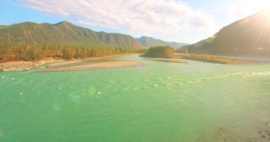 Güneşli yaz sabahında kayalarla birlikte taze, hızlı dağ nehri üzerinde alçak irtifa uçuşu..