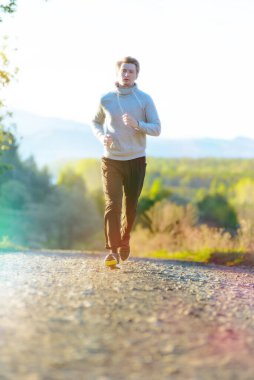 Güzel bir yaz gününde kırsal kesimde koşan bir adam. Spor fitness modeli Kafkasya etnik köken eğitimi.