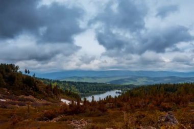 Dağ Gölü yaz ya da sonbahar zamanında zaman atlaması. Vahşi doğa ve kırsal alan. Bulutların hareketi, yeşil çimenler ve dramatik gökyüzü. Motorlu doli kaydırıcı