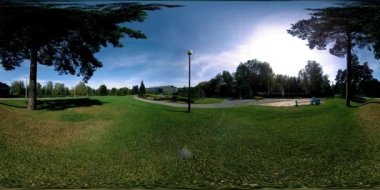 Bir şehir parkının UHD 4K 360 VR Sanal Gerçekliği. Sonbaharda ya da yaz gününde ağaçlar ve yeşil çimenler. Yol ve güneş ışınları. Özgün ses.