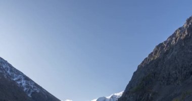 4K UHD dağ gölü zaman ayarlı yaz veya sonbahar saatlerinde. Vahşi doğa ve kırsal dağ vadisi. Çam ağaçlarından oluşan yeşil orman ve gökyüzünde hızlı bulutlar. Motorlu doli kaydırma hareketi