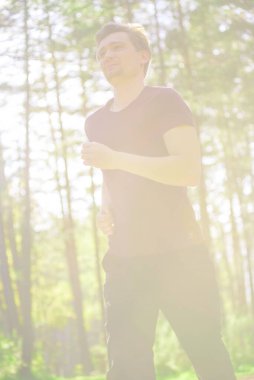 Koşan adam güzel bir yaz gününde şehir parkında koşuyor. Spor fitness modeli Kafkasya etnik köken eğitimi.