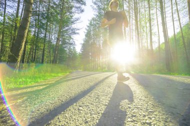 Koşan adam güzel bir yaz gününde şehir parkında koşuyor. Spor fitness modeli Kafkasya etnik köken eğitimi.