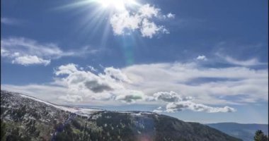 Dağların arkasındaki bulutların zaman çizelgesi. Kar, kayalar, uçurumlar ve derin mavi gökyüzü. Yüksek irtifa. Kamera hareketi.