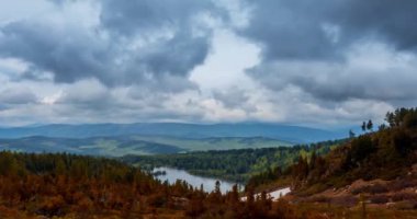 Dağ Gölü yaz ya da sonbahar zamanında zaman atlaması. Vahşi doğa ve kırsal alan. Hızlı bulutlar, yeşil çimenler ve dramatik gökyüzü. Motorlu doli kaydırma hareketi