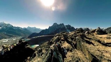 Gokyo Ri dağın tepesinde. Tibet Budist bayrağı. Vahşi Himalayalar yüksek irtifa doğa ve dağ vadisi. Buzla kaplı kayalık yamaçlar. Panorama hareketi