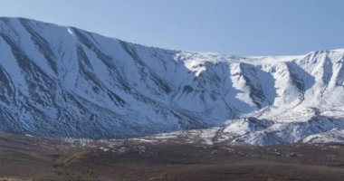 Güneş hareketinin 4K UHD zaman çizelgesi karlı dağın tepesinde kristal berrak gökyüzünde. Sonbahar otlağında sarı çimenler. Vahşi sonsuz doğa..