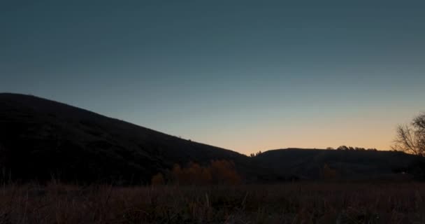 4K山の牧草地の時間の経過は 夏や秋の日の出の時間です 野生の自然と農村のフィールド 澄んだ空 緑と黄色の草 水平線に太陽の光 電動スライダーの動き — ストック動画
