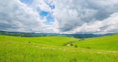 Yaz ya da sonbahar mevsiminde dağdaki çayır zaman atlaması. Vahşi doğa ve kırsal alan. Hızlı bulut hareketleri, yeşil çimenler ve güneş ışınları. Motorlu Panorama