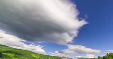 Yaz ya da sonbahar mevsiminde dağdaki çayır zaman atlaması. Vahşi doğa ve kırsal alan. Bulutların hareketi, yeşil çimenler ve güneş ışınları. Motorlu Panorama