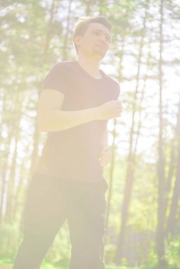 Koşan adam güzel bir yaz gününde şehir parkında koşuyor. Spor fitness modeli Kafkasya etnik köken eğitimi.