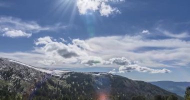 Dağların arkasındaki bulutların zaman çizelgesi. Kar, kayalar, uçurumlar ve derin mavi gökyüzü. Yüksek irtifa. Kamera hareketi.