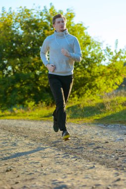 Koşan adam güzel bir yaz gününde kırsal alanda koşuyor. Spor fitness modeli Kafkasya etnik köken eğitimi.