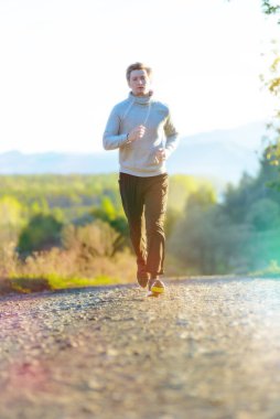 Koşan adam güzel bir yaz gününde kırsal alanda koşuyor. Spor fitness modeli Kafkasya etnik köken eğitimi.