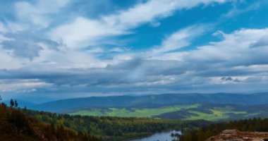 Dağ Gölü yaz ya da sonbahar zamanında zaman atlaması. Vahşi doğa ve kırsal alan. Hızlı bulutlar, yeşil çimenler ve dramatik gökyüzü. Motorlu doli kaydırma hareketi