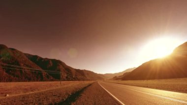 4K UHD dağ yolu zaman ayarlı yaz ya da sonbahar günbatımı gündoğumu saatinde. Vahşi Rus doğası ve kırsal alan. Yeşil çayır ve güneş ışınları hareketi.