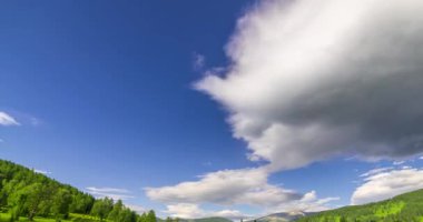 Yaz ya da sonbahar mevsiminde dağdaki çayır zaman atlaması. Vahşi doğa ve kırsal alan. Bulutların hareketi, yeşil çimenler ve güneş ışınları. Motorlu Panorama