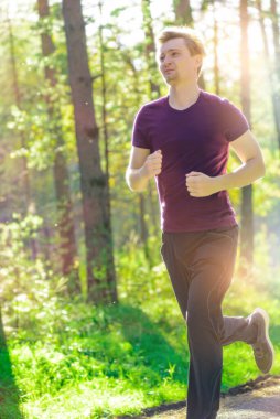Koşan adam güzel bir yaz gününde şehir parkında koşuyor. Spor fitness modeli Kafkasya etnik köken eğitimi.