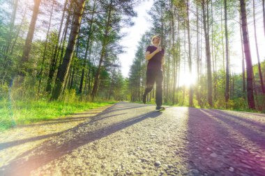 Koşan adam güzel bir yaz gününde şehir parkında koşuyor. Spor fitness modeli Kafkasya etnik köken eğitimi.