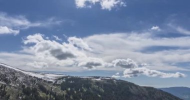 Dağların arkasındaki bulutların zaman çizelgesi. Kar, kayalar, uçurumlar ve derin mavi gökyüzü. Yüksek irtifa. Kamera hareketi.