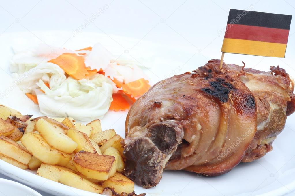 German BBQ pork knuckle served with french fries and salad.