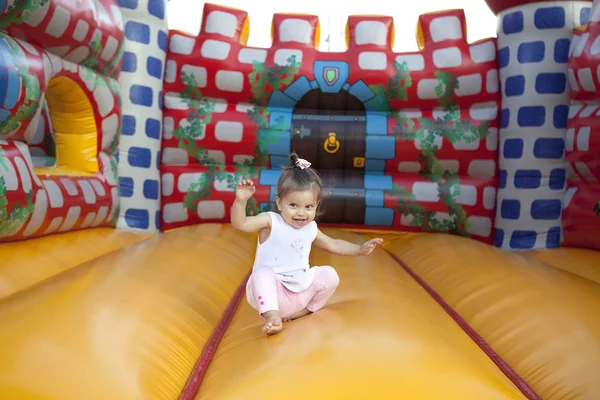 Criança brincando em um castelo inflável — Fotografia de Stock