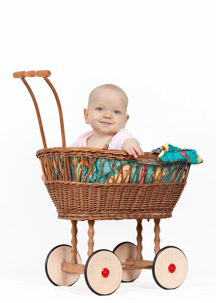 Ung flicka i wicker barnvagn — Stockfoto