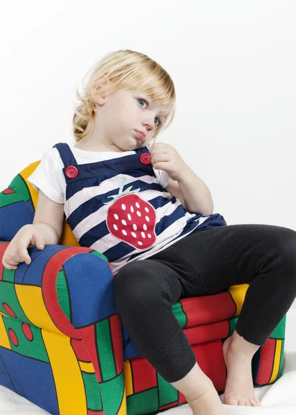 Little girl in a colorful armchair — Stock Photo, Image