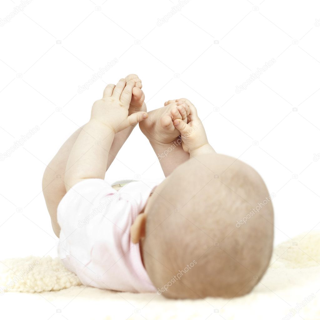Young baby playing with her toes