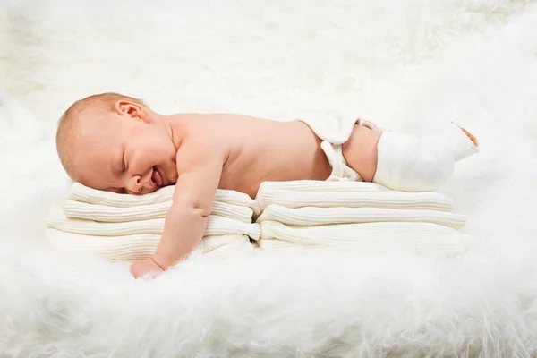 Cute baby boy lying on stack of towels Royalty Free Stock Photos