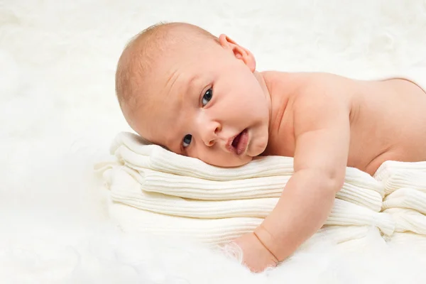 Lindo bebé niño acostado en la pila de toallas Imágenes de stock libres de derechos
