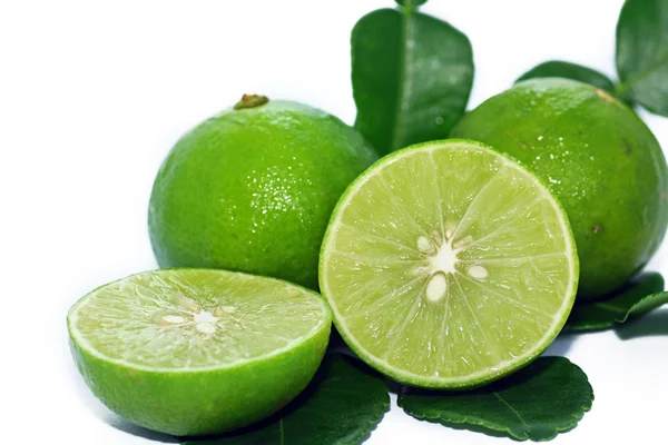 Limes met segmenten en bladeren — Stockfoto