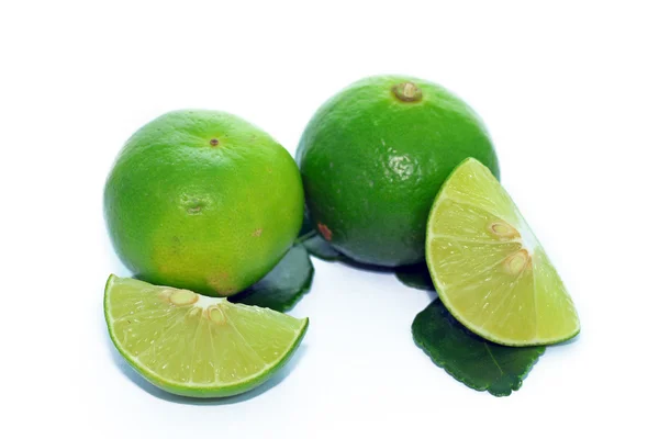 Limes with slices and leaves — Stock Photo, Image