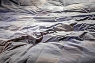 Gece uyuduktan sonra dağınık bir yatak örtüsünün üst görüntüsü.