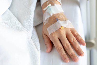 Woman's hand piercing needle to give saline solution