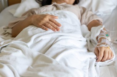 Woman's hand piercing needle to give saline solution