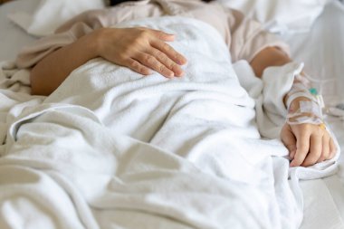 Woman's hand piercing needle to give saline solution