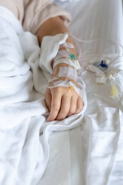 Woman's hand piercing needle to give saline solution