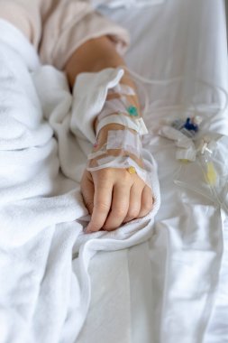 Woman's hand piercing needle to give saline solution