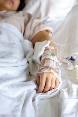 Woman's hand piercing needle to give saline solution