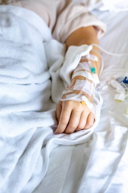 Woman's hand piercing needle to give saline solution