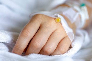 Woman's hand piercing needle to give saline solution