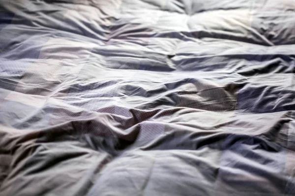 Gece uyuduktan sonra dağınık bir yatak örtüsünün üst görüntüsü.