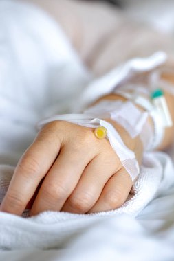 Woman's hand piercing needle to give saline solution