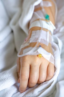 Woman's hand piercing needle to give saline solution