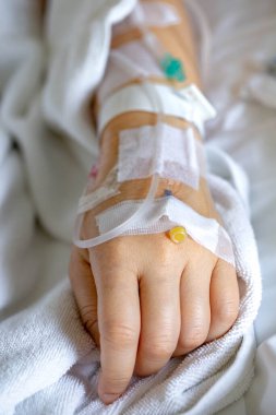 Woman's hand piercing needle to give saline solution